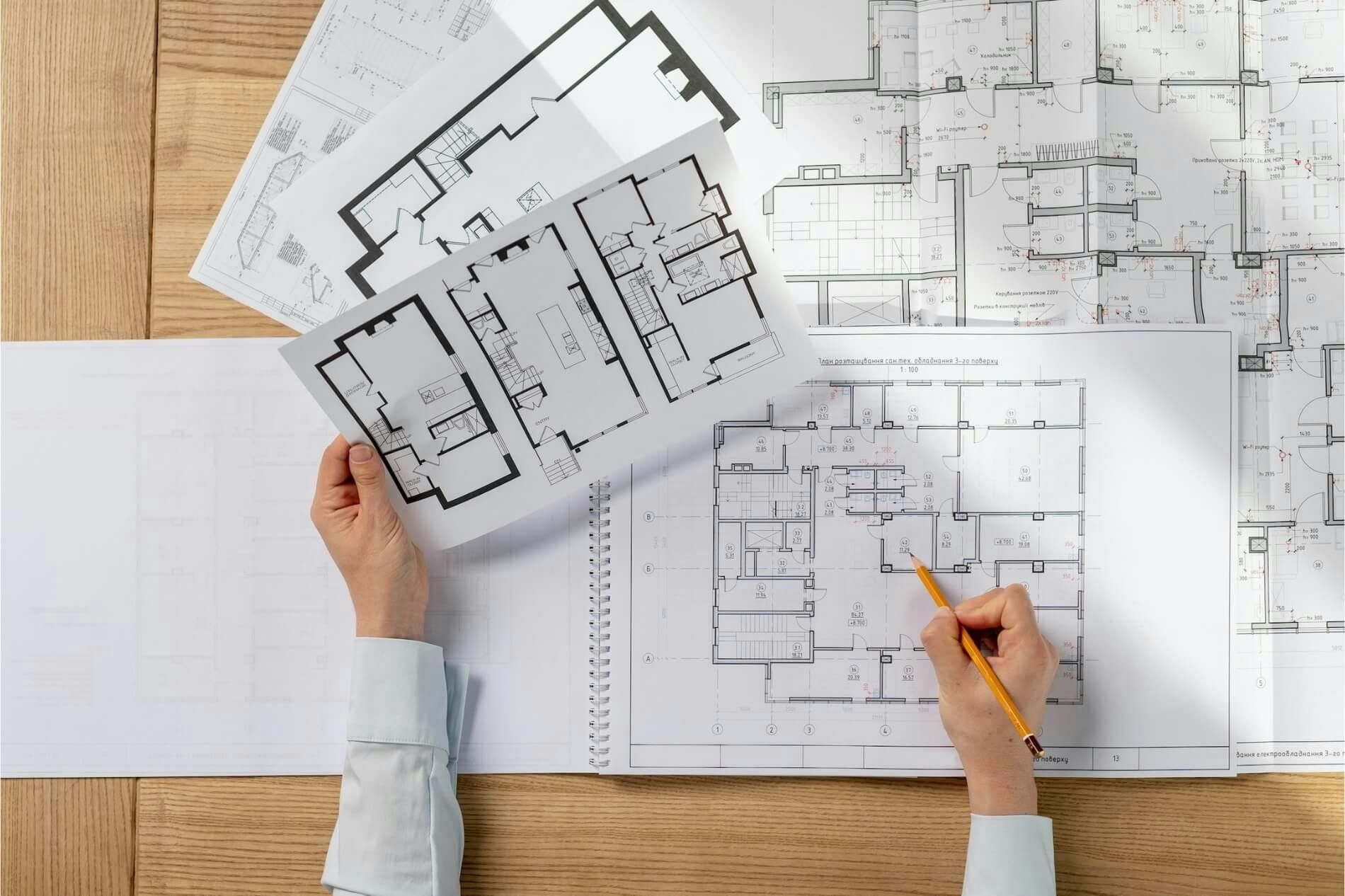Female design planner prepares blueprints for electrical contracting client