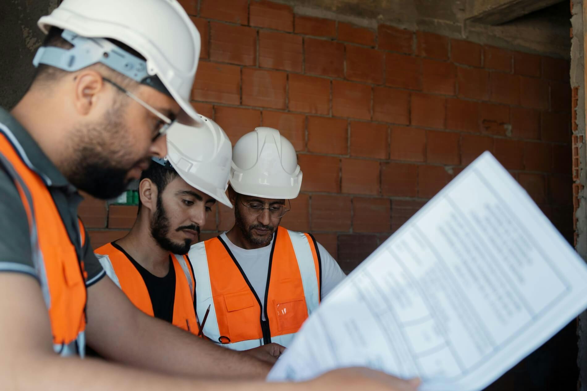Tradesmen reviewing blueprint designs at a construction site
