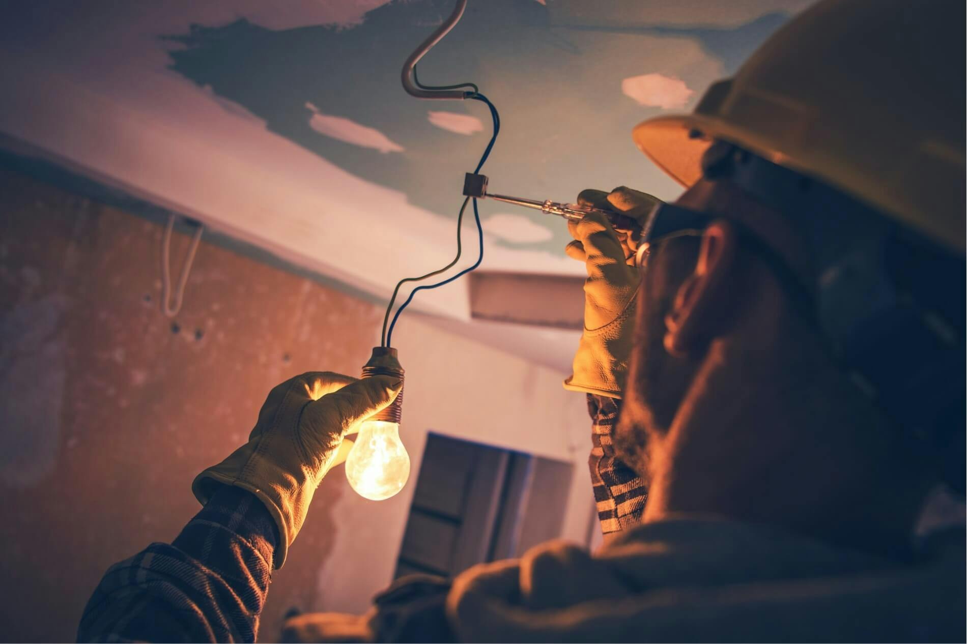 Electrician inspects incandescent bulb for functionality