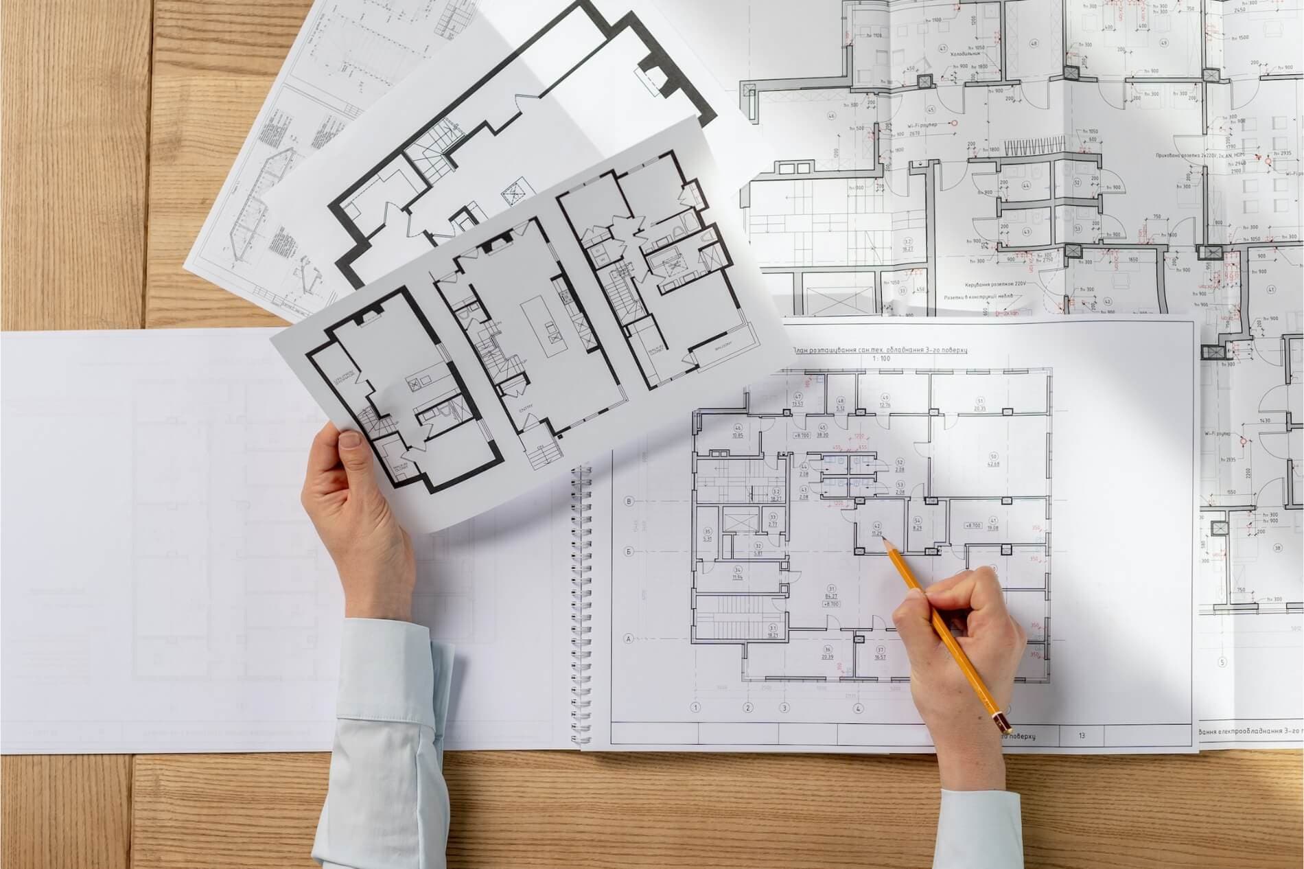Female design planner prepares blueprints for electrical contracting client