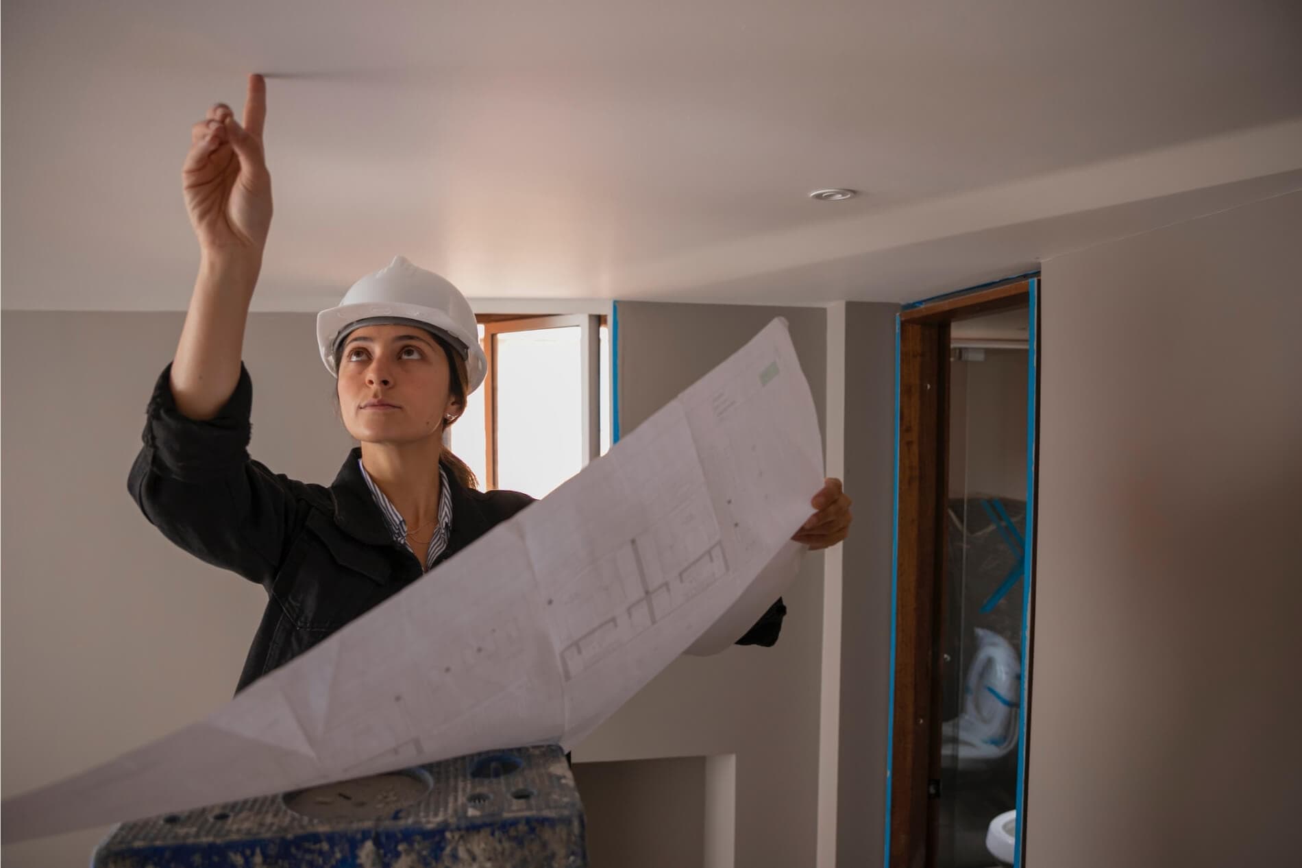 Female electrician begins planning recess lighting installation